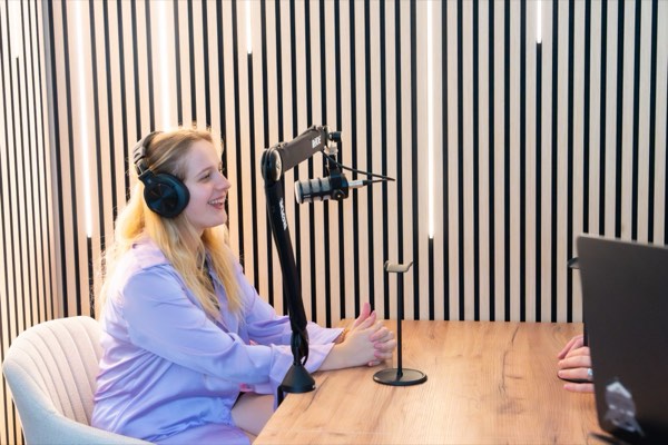 Podcast recording from the side – microphone on a boom arm and light wooden slats